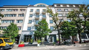 A multi-story hotel with a modern facade, balconies, and a ground-level entrance with potted plants. - Hotel Gdynia Boutique (Gdynia)