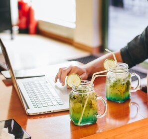 A laptop on a wooden table with two mason jars of green drink with lime slices. - Season at hulhumale (Hulhumalé)