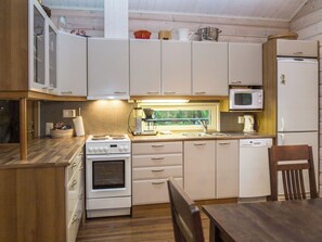A compact kitchen with a stove, microwave, and refrigerator. - Teerenpesä by Interhome (Nilsiä)