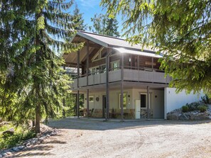 A two-story wooden house with a balcony, surrounded by trees. - Teerenpesä by Interhome (Nilsiä)