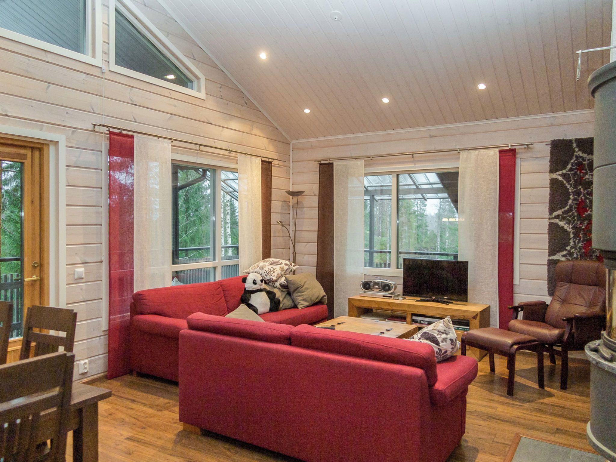 Una sala de estar acogedora con un sofá rojo, un televisor y una chimenea.