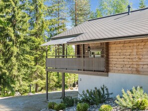 A wooden cabin with a balcony, surrounded by trees. - Teerenpesä by Interhome (Nilsiä)