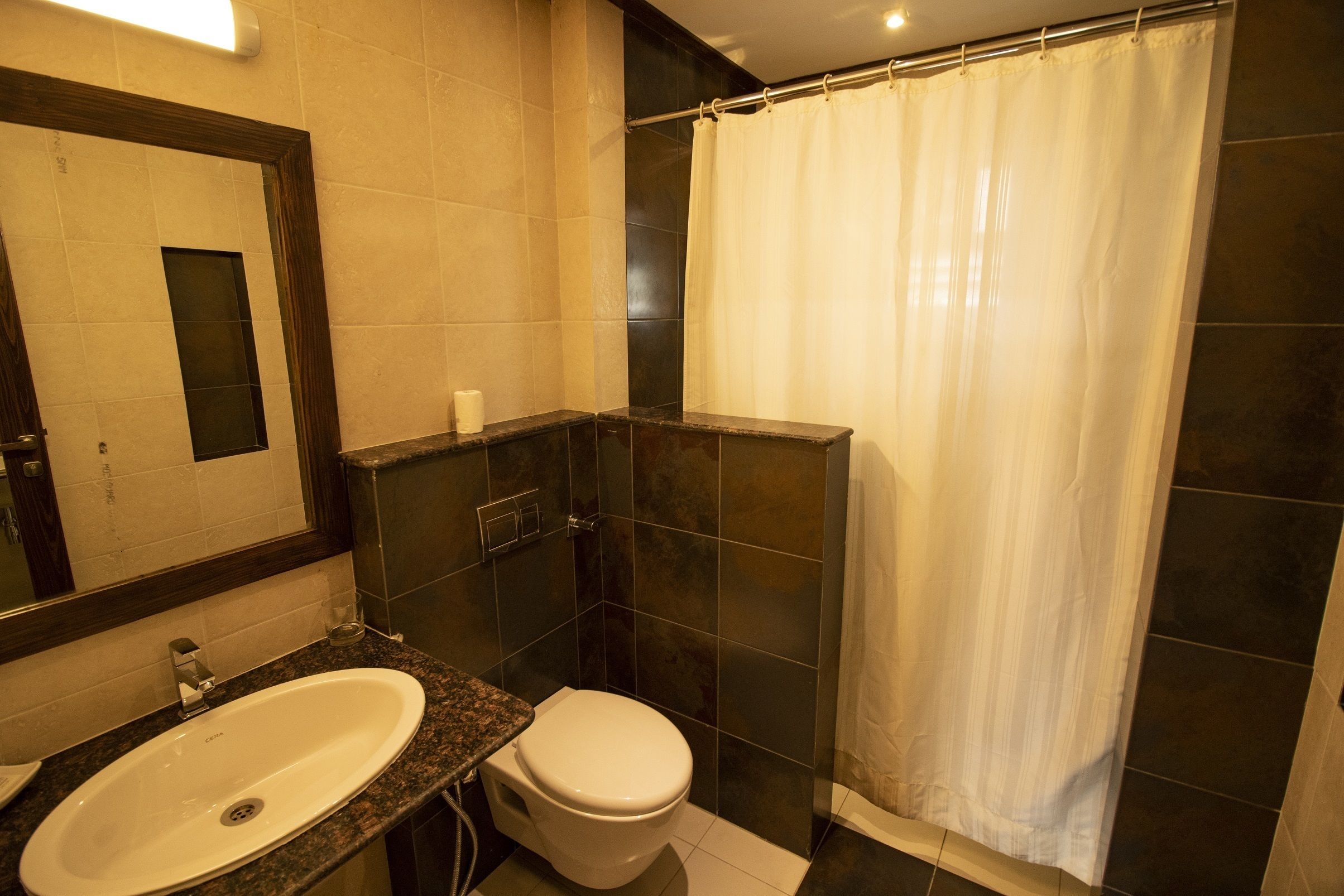 Un baño con lavabo, inodoro y cortina de ducha.