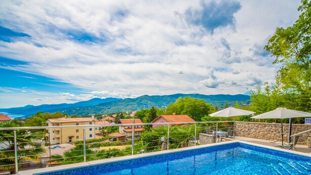 A swimming pool with a clear view of the surrounding landscape, including houses and mountains in the background. - Koalas Nest Home & Apartments by Interhome (Opatija/Matulji)