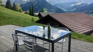 A table with chairs on a terrace with a mountain view.