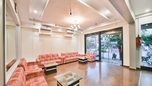 A spacious lobby with patterned sofas, a glass coffee table, and a view of the street through large glass doors. - Ardency Inn by Park Tree Udaipur (Udaipur)