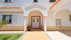 A two-story building with a central entrance, white walls, and yellow trim.