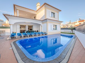 A modern villa with a swimming pool, sun loungers, and a covered patio area. - Colibri by Interhome (Gale)