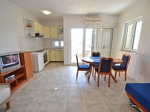 A compact kitchen with a dining area, a TV, and a sofa. - Apartment Golub by Interhome (Karlobag)