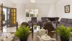 Una sala de estar con un conjunto de sofá, una chimenea y plantas en macetas.