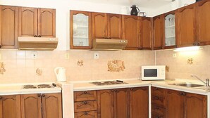 Una cocina con armarios de madera, un microondas y un lavabo.