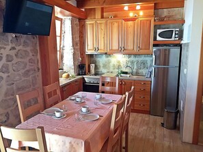 Enjoy meals at the dining table in this kitchen with a stove, microwave, and refrigerator.