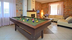 A pool table in a room with stone walls, a fireplace, and a sofa. - Vacation home Marija by Interhome (Oklaj)