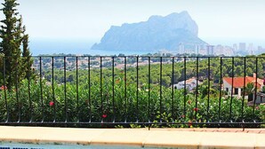 Una piscina con vistas a un paisaje montañoso y un horizonte urbano a lo lejos.