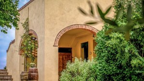 A building with a beige facade, two brick arches, and a wooden door. - Podere La Torre by Interhome (Certaldo)