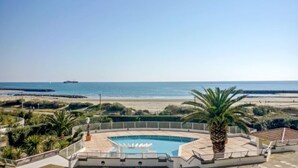 Un espace piscine offrant une vue sur la plage et l’océan.