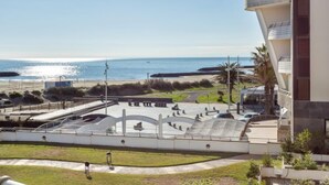 Een kustgezicht met een modern gebouw, een strand en een skatepark.