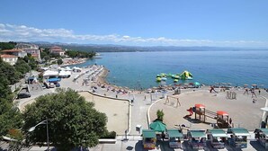Une zone côtière comprenant une plage, un parking et une vue sur la mer.