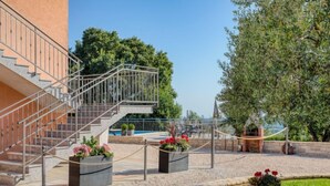 Un bâtiment doté d’un escalier, d’un espace extérieur aménagé pour s’asseoir et d’une piscine.