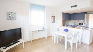 Una cocina moderna con comedor, televisor y ventana.