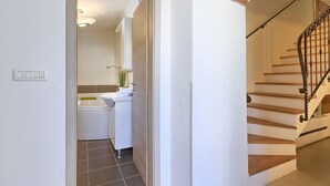 Un baño moderno con bañera, lavamanos y espejo.