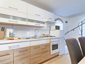 Een koelkast, een magnetron, een oven, kookgerei, borden en bestek