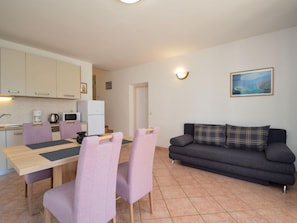 A compact living space with a dining area, kitchenette, and a sofa. - Apartment Mladen by Interhome (Vodice)