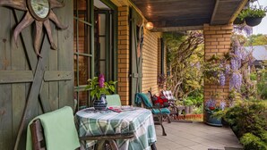 A patio area with a table and chairs, a sun-shaped decoration, and a brick wall. - Modlinek by Interhome (Ustka)