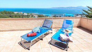 A balcony with two sun loungers, a red water bottle, and a towel. - Niviroma by Interhome (Llançà)
