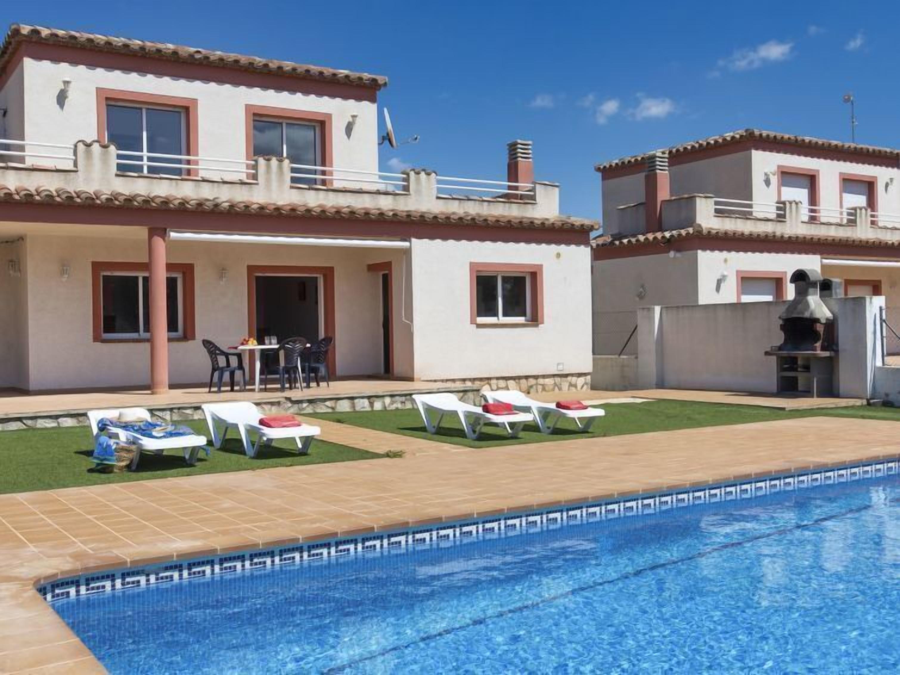 Une maison à deux étages avec une piscine, un espace extérieur aménagé et un coin barbecue.