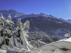 Paesaggio montano innevato con una cittadina situata ai piedi.
