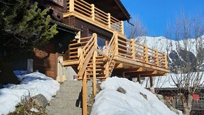 A wooden cabin with a wooden staircase leading to a balcony. - Château Lapin by Interhome (Verbier)