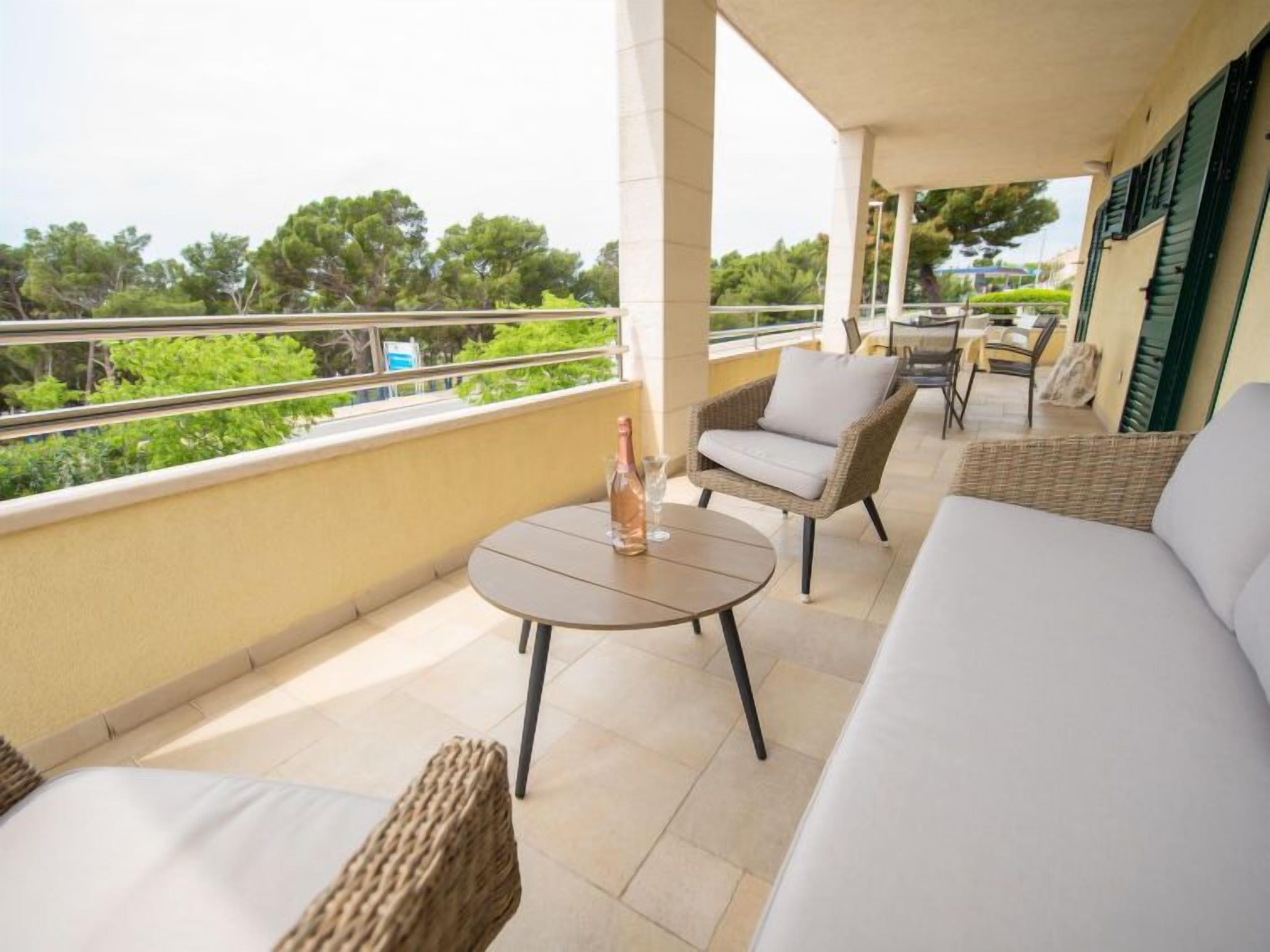 Un balcone con divano, sedie e tavolo.