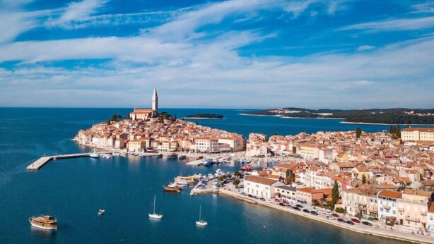 A coastal town with a prominent church on a hill, a marina with boats, and a clear blue sky. - Romantika by Interhome (Rovinj)