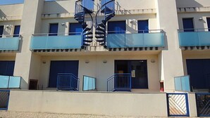 A modern building with a central spiral staircase, multiple balconies, and a flat facade. - Vacation home Minini by Interhome (L'Ampolla)