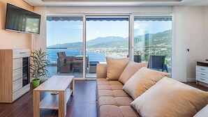 A modern living room with a sofa, a coffee table, and a TV mounted on the wall. - Vacation home Vista by Interhome (Opatija/Matulji)