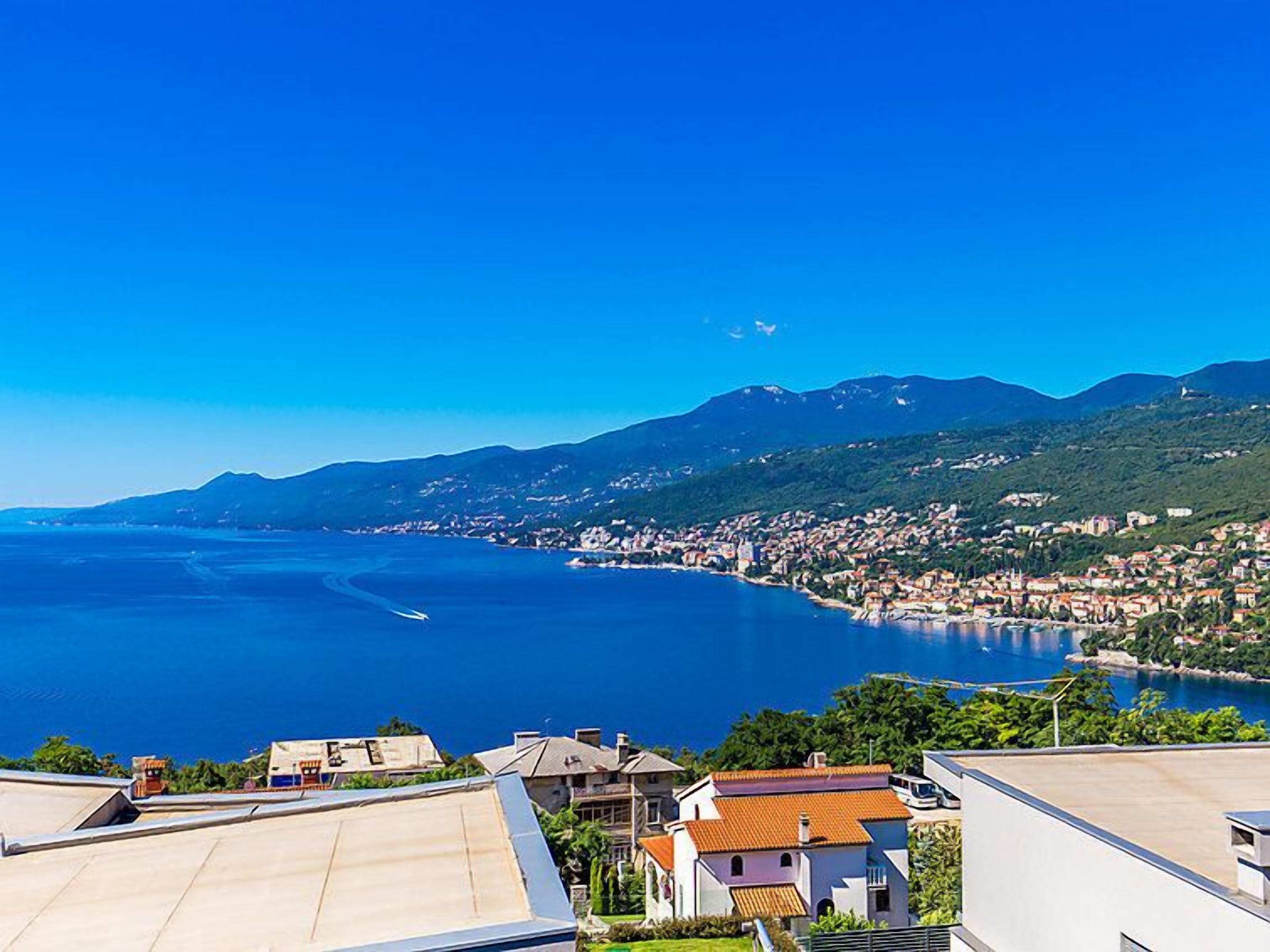 A coastal town with a view of the sea and mountains in the background.