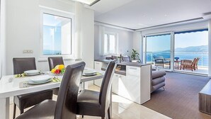 A modern kitchen with a dining area, large windows, and a view of the sea. - Vacation home Vista by Interhome (Opatija/Matulji)