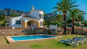 Une maison à deux étages avec une piscine, un patio couvert et une vue sur les montagnes.