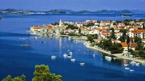 A coastal town with a central church, boats in the harbor, and a clear blue sky. - Apartment Sablić by Interhome (Pirovac)