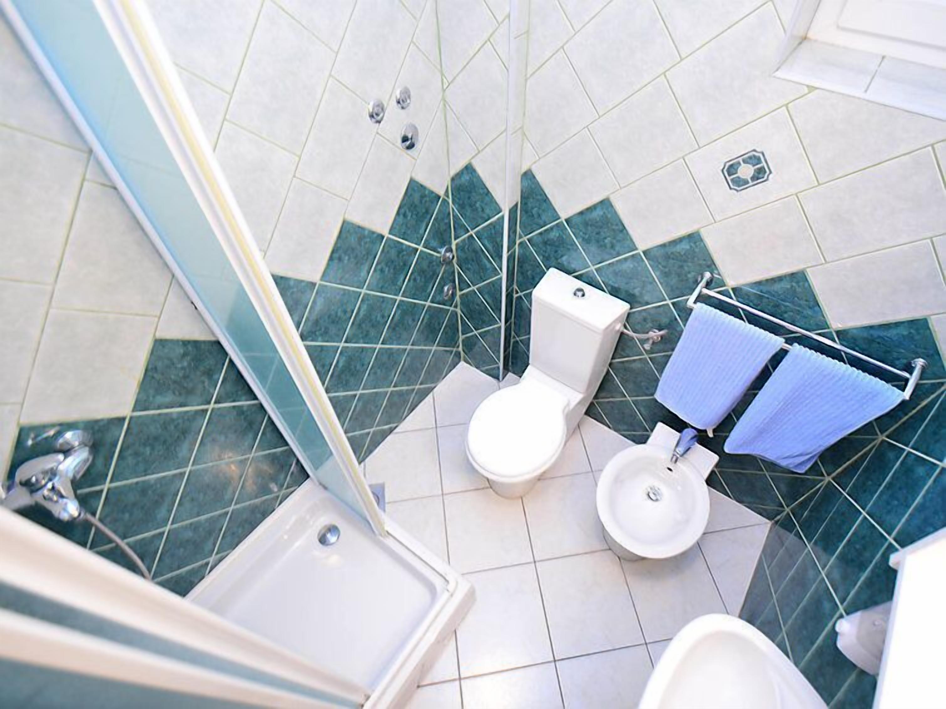 Une salle de bain équipée de toilettes, d’un bidet et d’une baignoire.