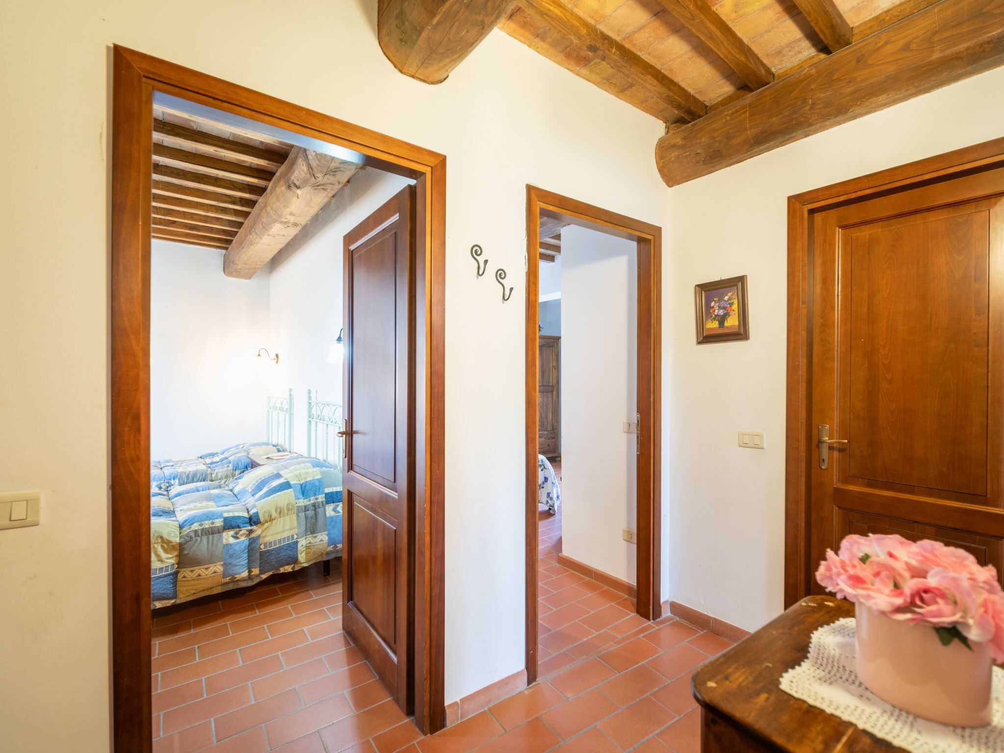 Une chambre à coucher avec un lit, une porte en bois et un couloir menant à une autre pièce.