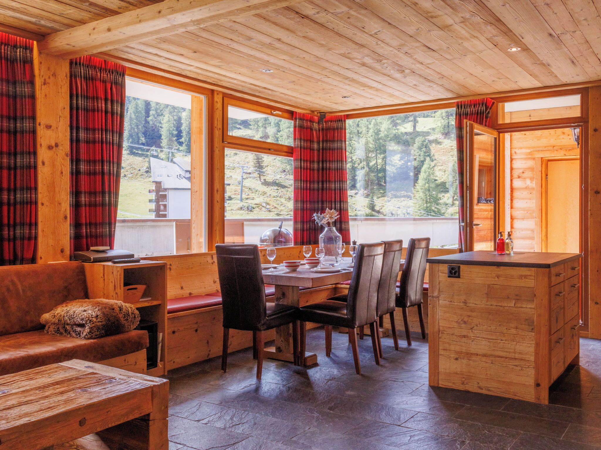 Ein gemütliches Holzhaus-Interieur mit Essbereich, Sofa und einer Bank.