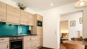 Une cuisine moderne avec des armoires en bois, un pare-feu turquoise et des appareils électroménagers en acier inoxydable.
