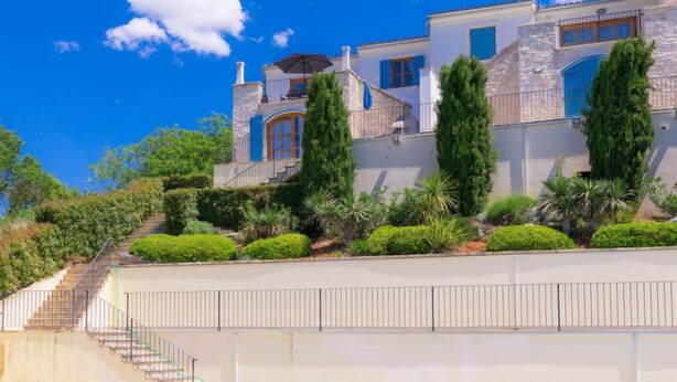 A multi-story house with a stone facade, blue shutters, and a staircase leading to the upper levels. - Vacation home Nini by Interhome (Buje)