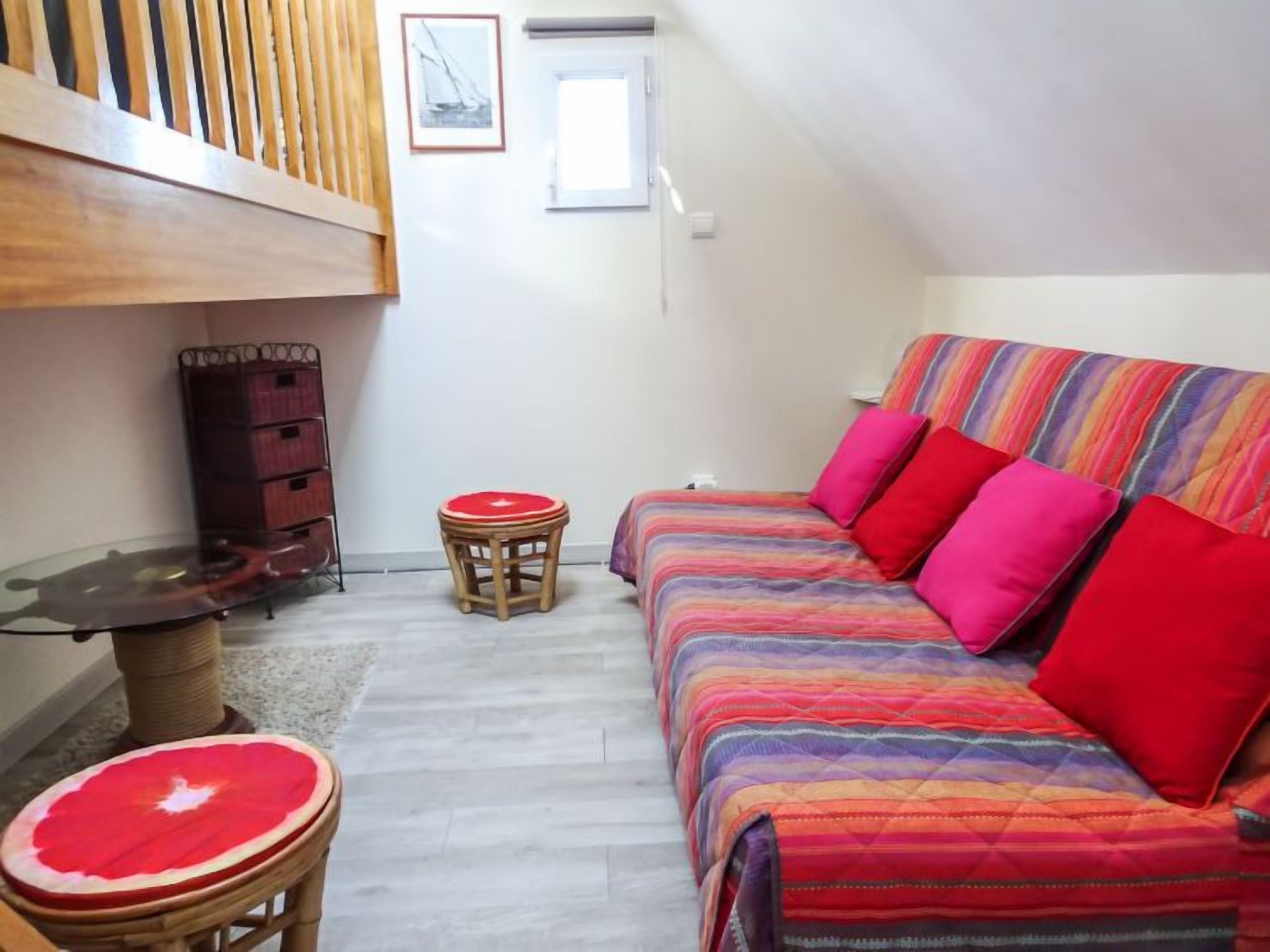 A cozy room with a bed, a small table, and a chair. There is a window and a door.