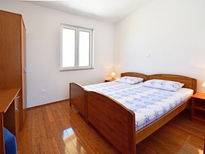 A bedroom with a wooden bed, a window, and a wardrobe.