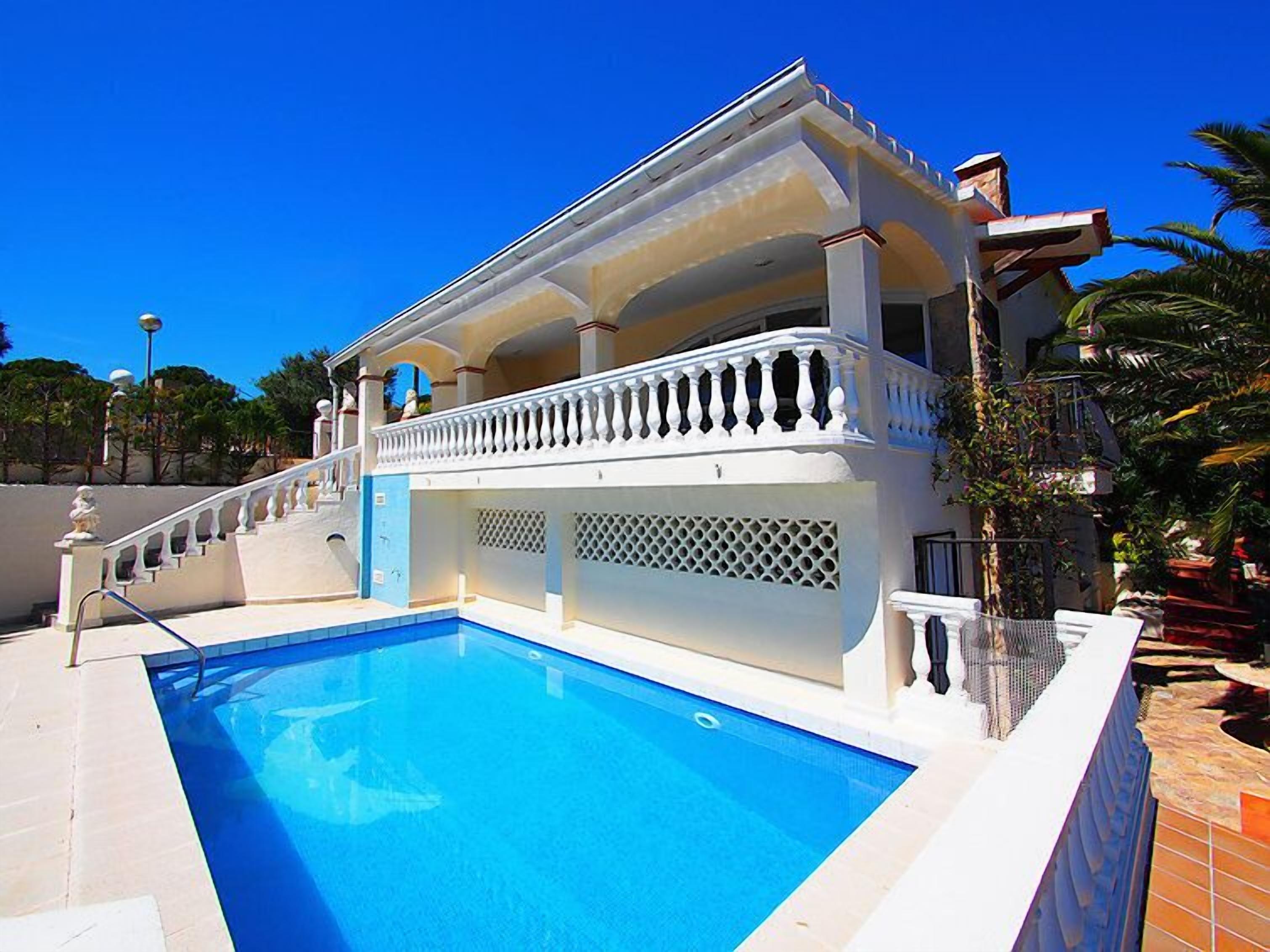 Um edifício de dois andares com uma piscina na frente.