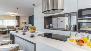 A modern kitchen with a central island, stainless steel appliances, and a large mirror above the sink.