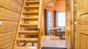 A wooden interior with a staircase leading to a living area. - Rentotahko by Interhome (Nilsiä)